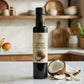 Bottle of coconut white infused balsamic vinegar on a kitchen counter with coconuts